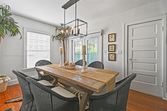 dining space featuring an inviting chandelier and dark wood-type flooring