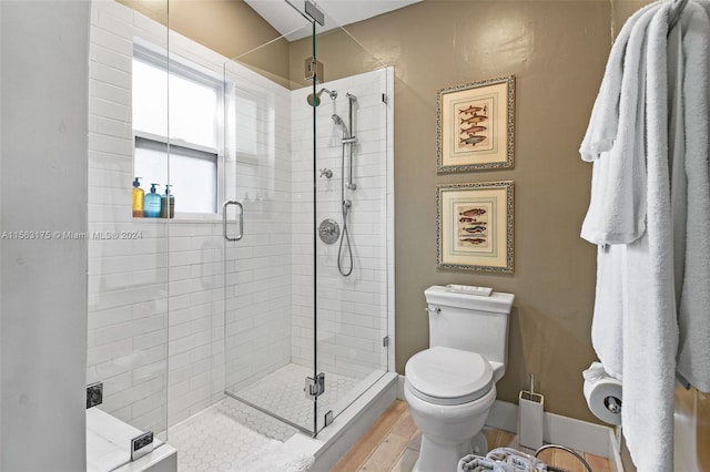 bathroom with a shower with door and toilet