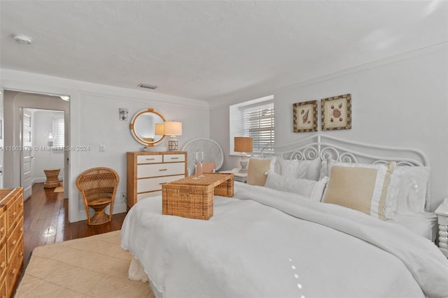 bedroom with crown molding and light wood-type flooring