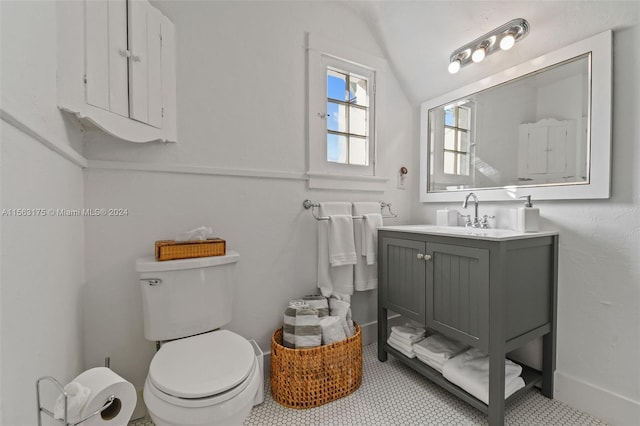 bathroom featuring vanity, lofted ceiling, tile flooring, and toilet