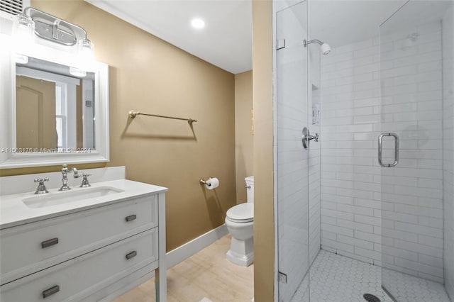 bathroom featuring a shower with door, toilet, and vanity