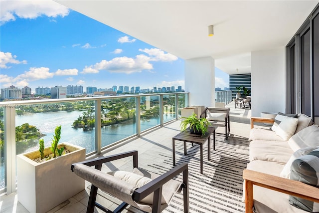 balcony featuring a view of city, a water view, and an outdoor hangout area