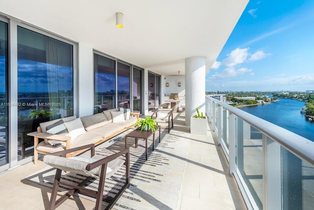 balcony featuring a water view and an outdoor living space