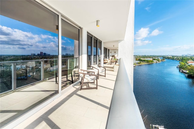 balcony featuring a water view and a city view