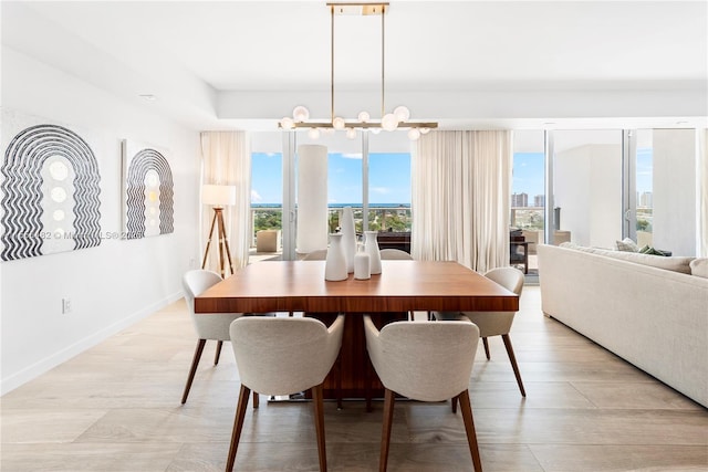 dining area with an inviting chandelier, light wood-style flooring, and baseboards