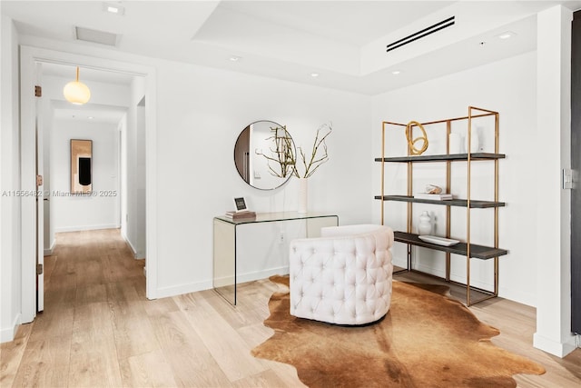 living area with baseboards, visible vents, and light wood finished floors