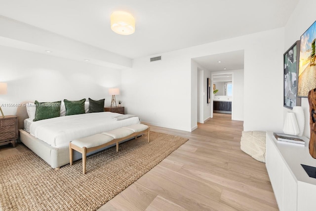 bedroom featuring light wood finished floors, visible vents, and baseboards