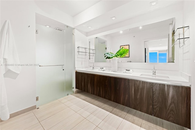 full bathroom with double vanity, a stall shower, visible vents, and a sink