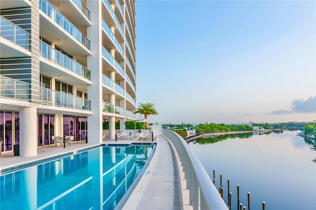 community pool with a patio and a water view