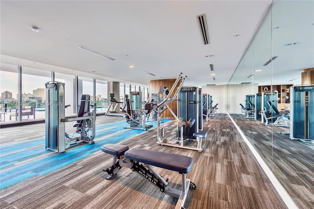 gym featuring carpet floors, expansive windows, and visible vents