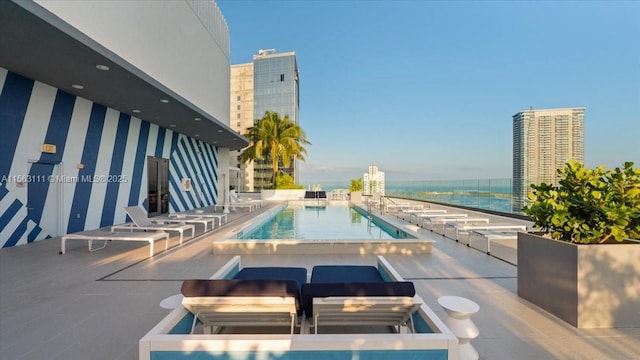 view of pool with a water view and a patio area