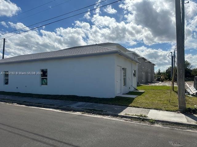 view of side of home with a yard