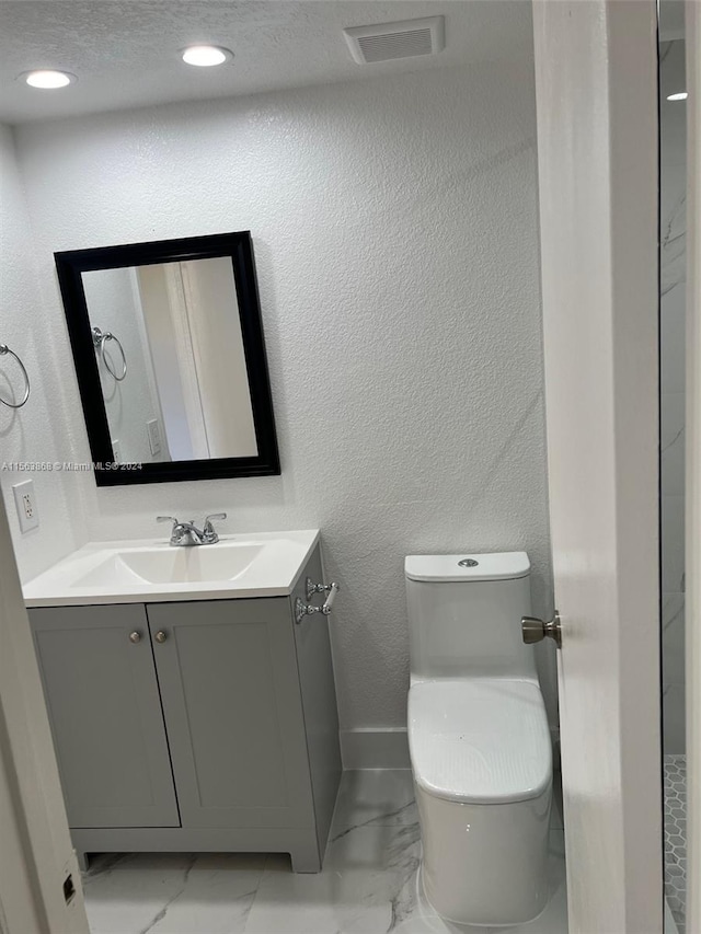 bathroom with vanity, tile flooring, a textured ceiling, and toilet