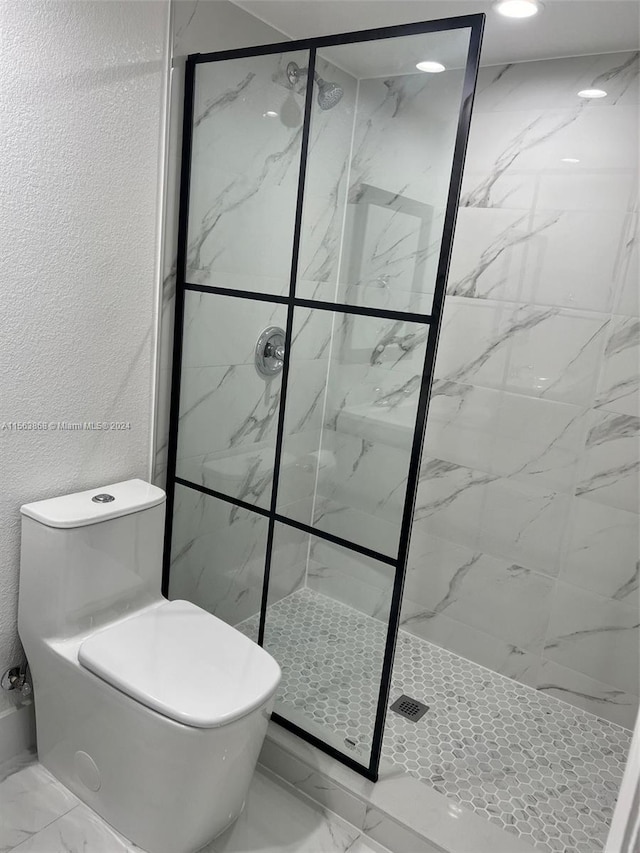 bathroom with tile floors, a shower with door, and toilet