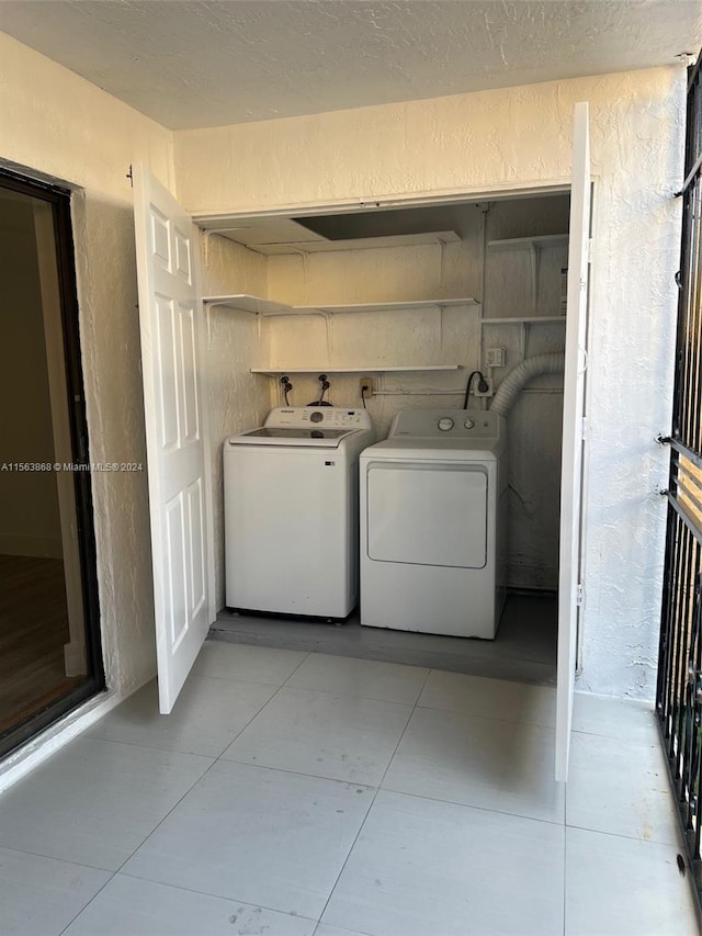 laundry area featuring washer and dryer, washer hookup, light tile floors, and electric dryer hookup