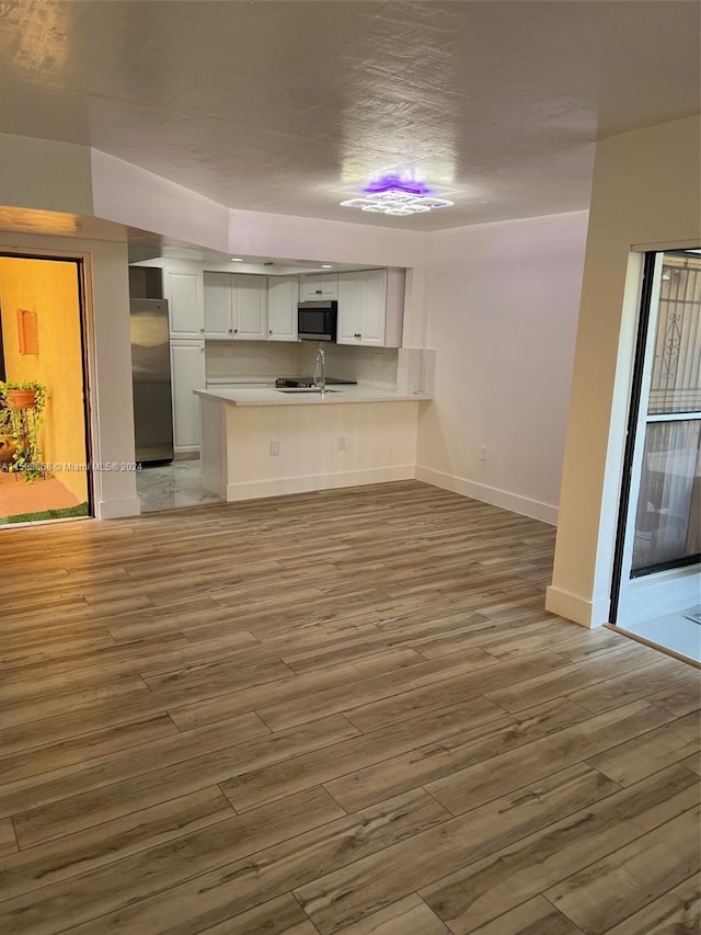 unfurnished living room featuring light wood-type flooring and sink