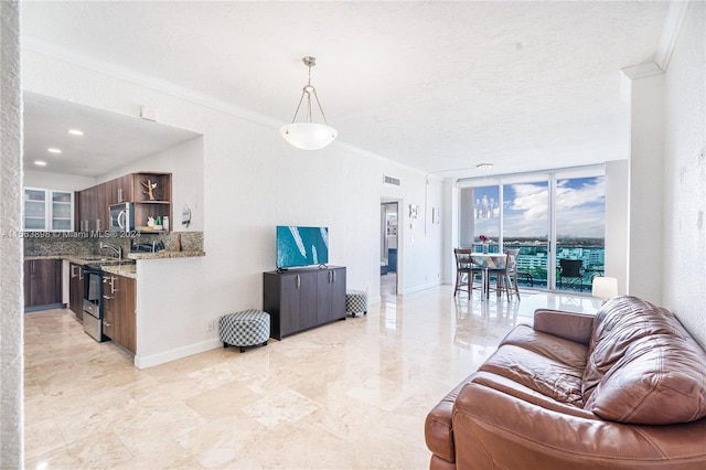 living room with a textured ceiling, light tile floors, sink, and crown molding