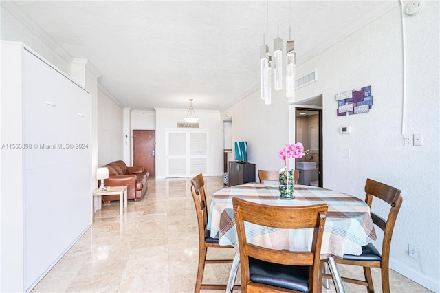 dining room with light tile floors, a textured ceiling, and ornamental molding