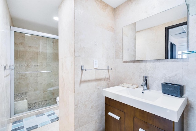 bathroom with vanity, tile walls, toilet, and walk in shower