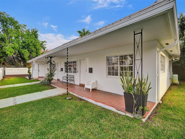 ranch-style house with a patio area and a front lawn