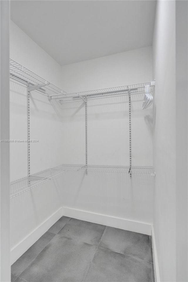 walk in closet with tile flooring