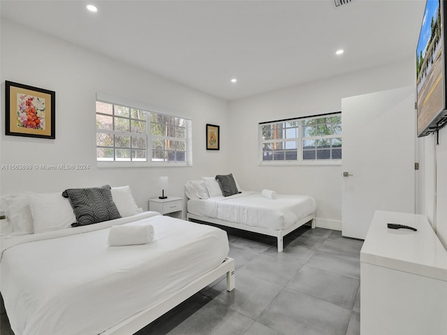 bedroom featuring light tile floors and multiple windows