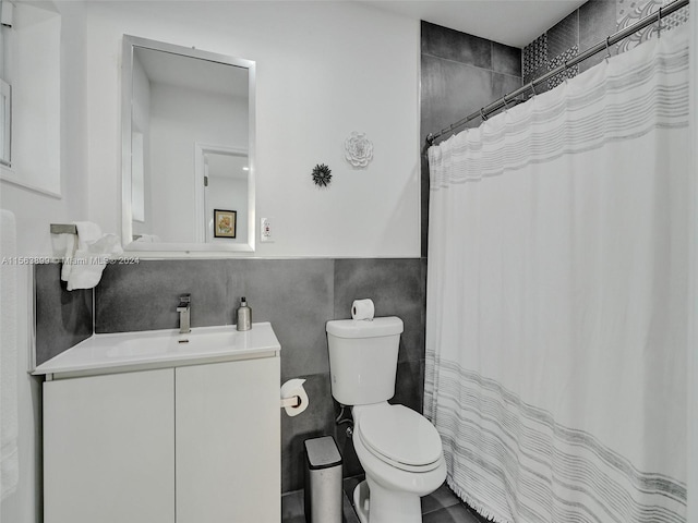 bathroom featuring vanity, tile walls, tile floors, toilet, and tasteful backsplash