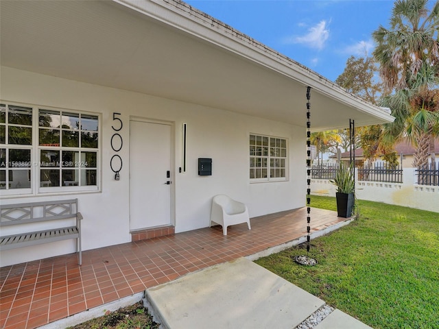 entrance to property with a lawn