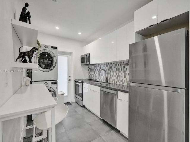 kitchen with stainless steel appliances, tasteful backsplash, light tile floors, and white cabinets