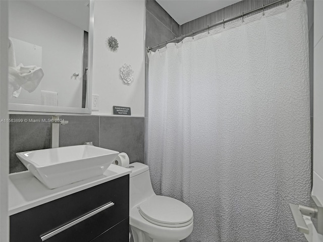 bathroom featuring tile walls, toilet, and vanity