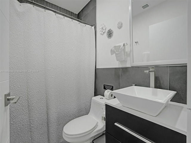 bathroom with backsplash, tile walls, toilet, and vanity