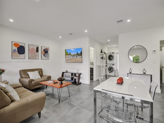 living room with stacked washer and clothes dryer and light tile floors