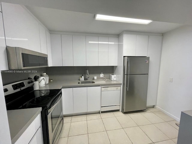 kitchen with light tile floors, white cabinets, sink, and stainless steel appliances