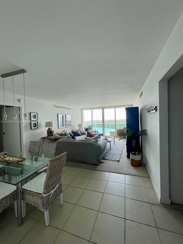 living room with floor to ceiling windows and light tile floors