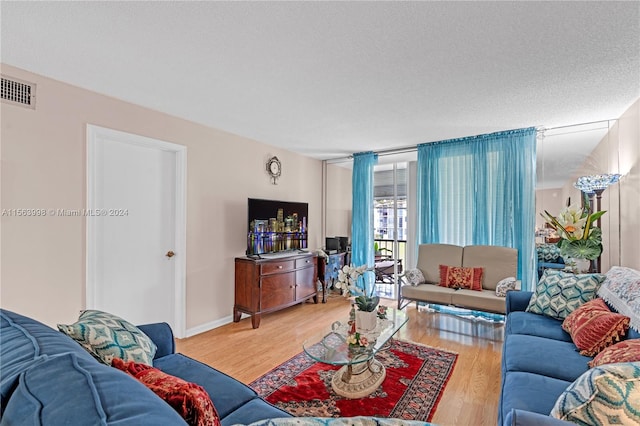 living room featuring a textured ceiling and light wood-type flooring