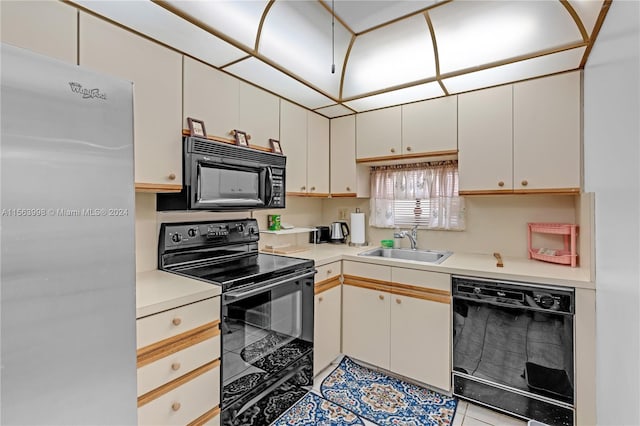 kitchen with light tile flooring, sink, white cabinetry, and black appliances