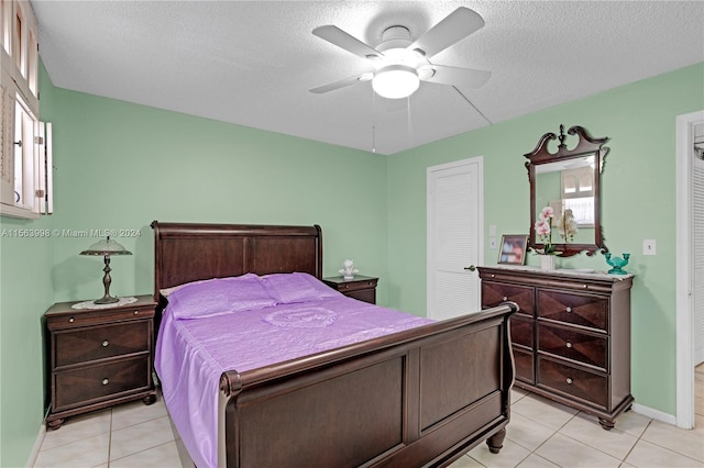 tiled bedroom featuring a textured ceiling, ceiling fan, and multiple windows