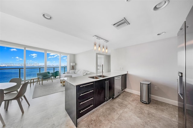 bathroom featuring expansive windows, a water view, and sink