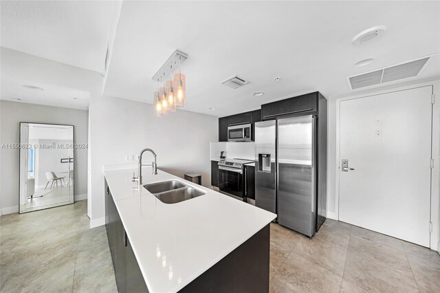 kitchen featuring decorative light fixtures, appliances with stainless steel finishes, sink, and light tile flooring