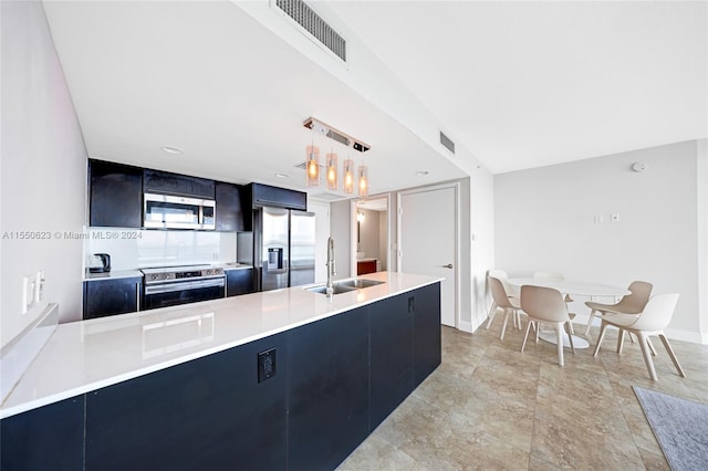 kitchen featuring stainless steel appliances, sink, light tile floors, and decorative light fixtures