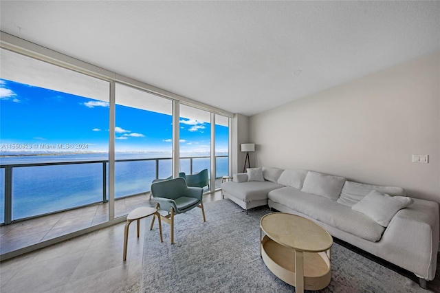 living room featuring a water view, expansive windows, and tile floors