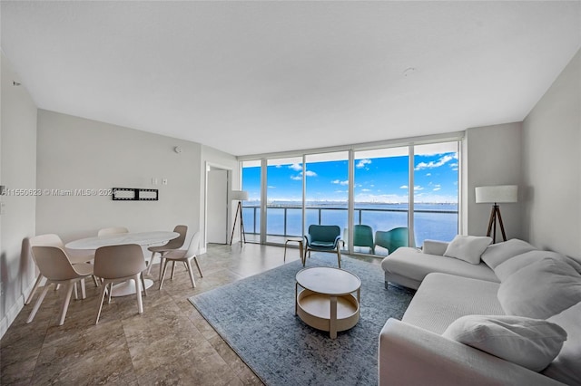 tiled living room featuring floor to ceiling windows and a water view