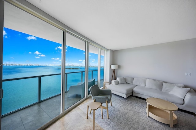 living room with tile patterned flooring, expansive windows, and a water view