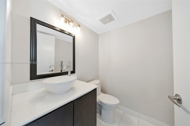 bathroom featuring vanity, tile patterned floors, and toilet