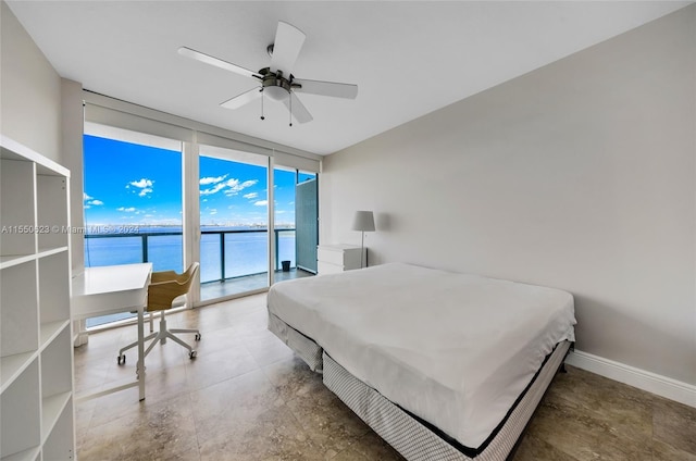 bedroom featuring access to outside, a wall of windows, ceiling fan, and a water view