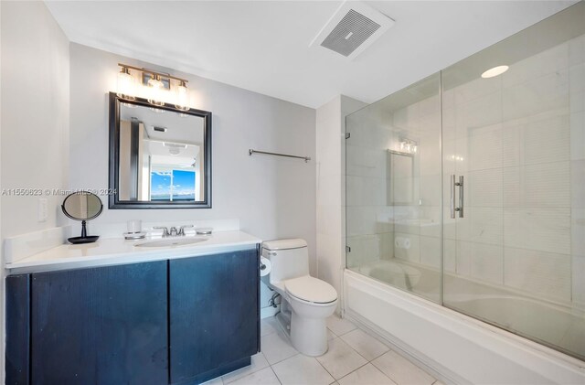 full bathroom with tile flooring, combined bath / shower with glass door, toilet, and vanity