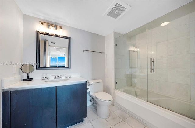 full bathroom featuring vanity, combined bath / shower with glass door, tile patterned floors, and toilet