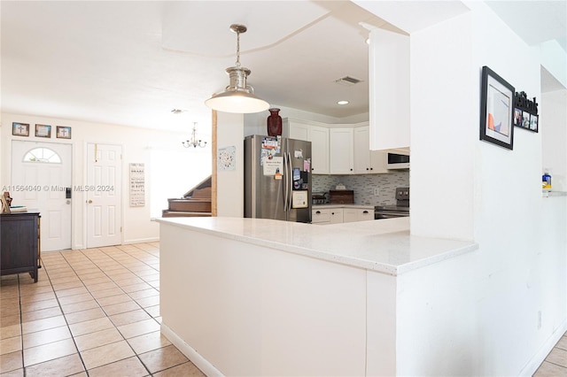 kitchen with stainless steel appliances, decorative light fixtures, kitchen peninsula, tasteful backsplash, and white cabinets