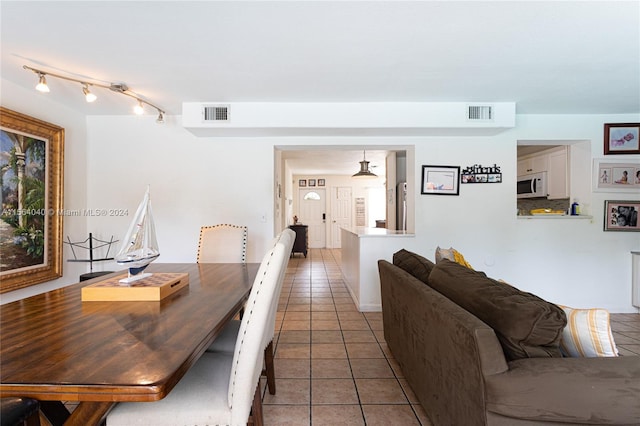 dining room featuring track lighting and tile flooring