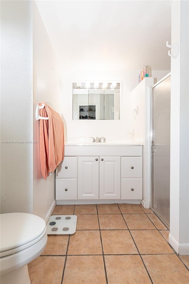 bathroom with walk in shower, toilet, tile floors, and vanity